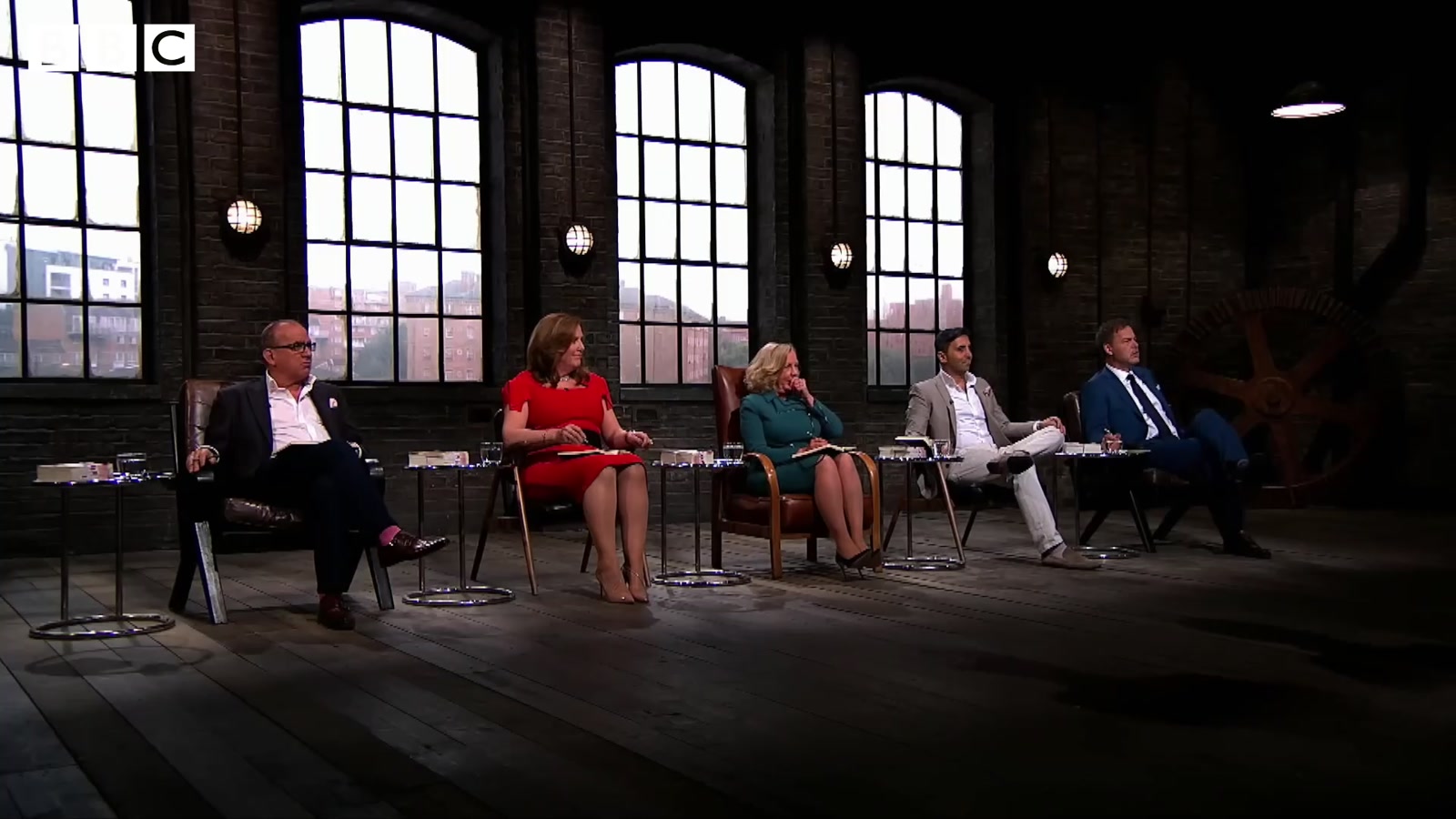 All five dragons seated in the Dragons' Den